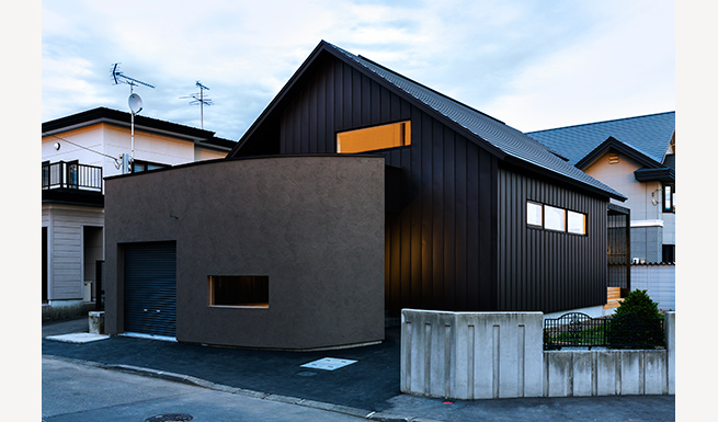 <em>リフォーム後</em>建物外観。平屋のヴォリュームに減築。塗壁とガルバリウム鋼板の外壁で全く違う表情となった。
