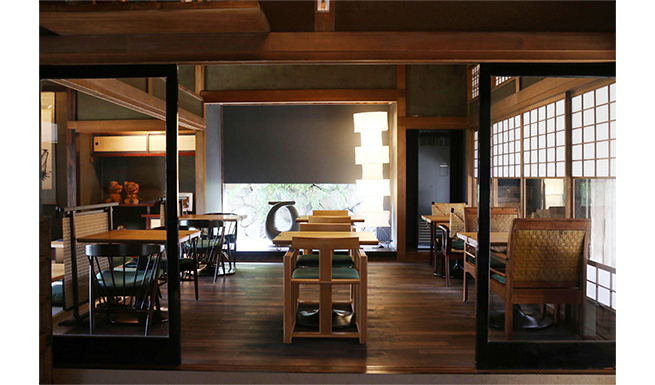 「翠」テーブル席。奥の床の間に腰窓をしつらえ、石垣を景色として切り取った。