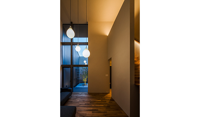 リビングからテラス越しにつながる中庭夕景。