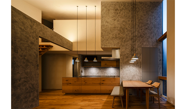 間接照明で浮かび上がる、リビングからのキッチン・ダイニング見返し夕景。