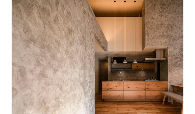 ハーフウォールとキッチン脇壁面はメインのケイソウ土塗との対比を意識したグレーのクイック＆イージー塗。