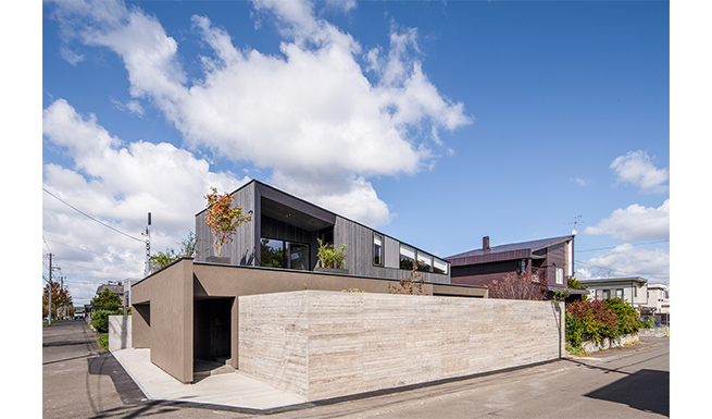 道路からの南側外観。向かいの雑木林が楽しめる2F屋上テラスには、更にプランターの植栽をしつらえた。