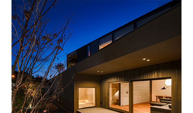 メインコートより軒の深いテラス越しにリビング、TATAMI ROOMを望む。