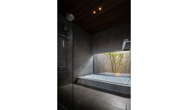 バスコートへと開いたオープンなバスルーム。